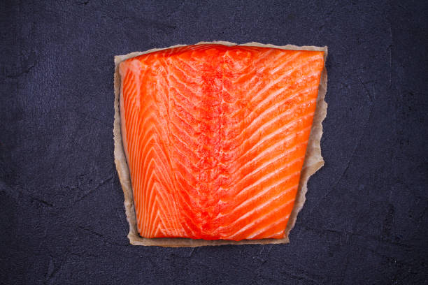 istock Fresh uncooked salmon fish on black background. Flatlay food setting 1084004188
