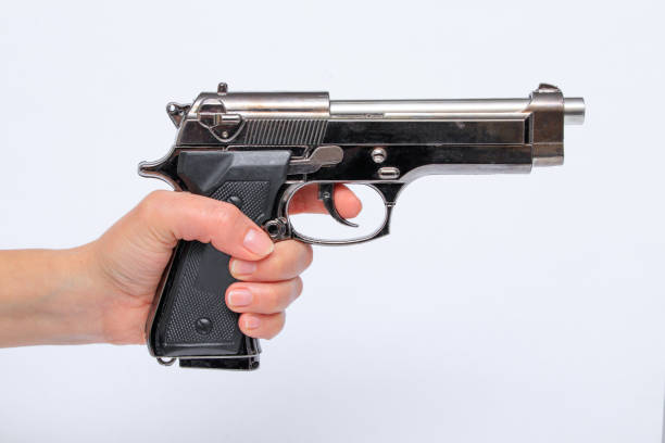 mujer sosteniendo la pistola en la mano - gun women handgun armed forces fotografías e imágenes de stock