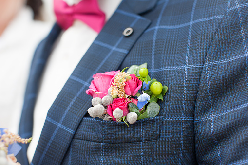 Nice wedding accessory on the plaid suit of the groom during the wedding ceremony