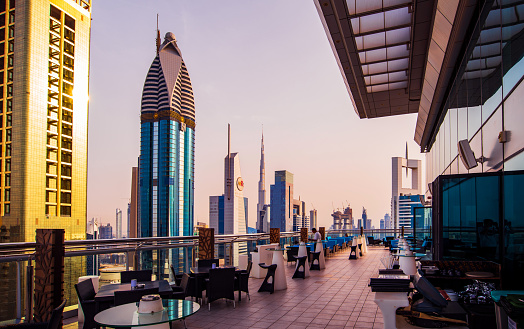 Dubai, United Arab Emirates - April 3, 2018: Modern skyscrapers of downtown Dubai from a rooftop coffee bar at sunset, modern architecture of UAE