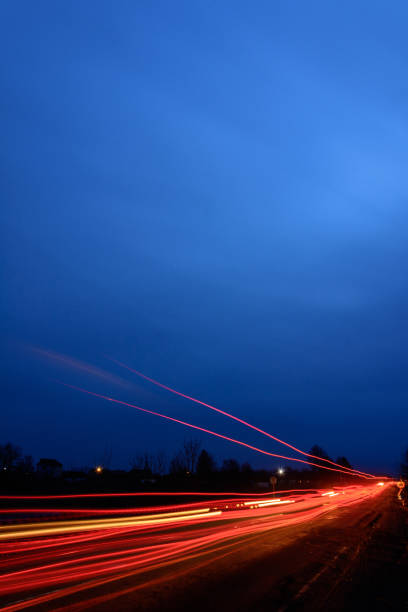 Headlights of cars, taken with long-term exposure to the background of the sky Photos of Ukrainian roads under the evening sky, on which cars are moving and blurring the way with their lightPhotos of Ukrainian roads under the evening sky, on which cars are moving and blurring the way with their light long shutter speed stock pictures, royalty-free photos & images