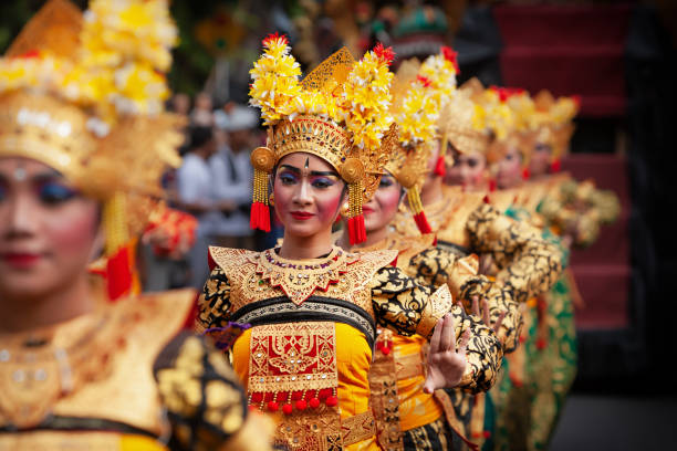 DENPASAR, BALI ISLAND, INDONESIA - JUNE 23, 2018: Face portrait of beautiful young Balinese women in ethnic dancer costume, dancing traditional temple dance Legong at art and culture festival parade.