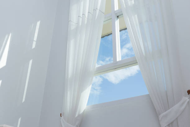 istock white curtain on the window with blue sky 1084027054