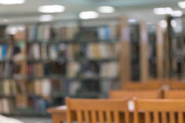istock bookshelf and table desk in library, education abstract blur defocused background 1084029066