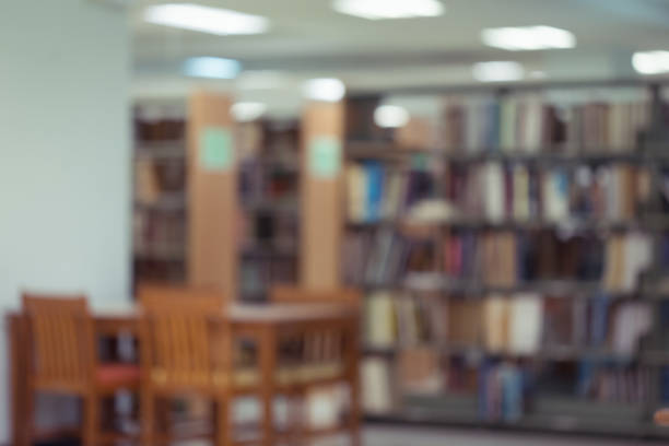 istock bookshelf and table desk in library, education abstract blur defocused background 1084029112