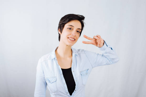 istock Woman in Studio Showing Peace Sign 1084032604