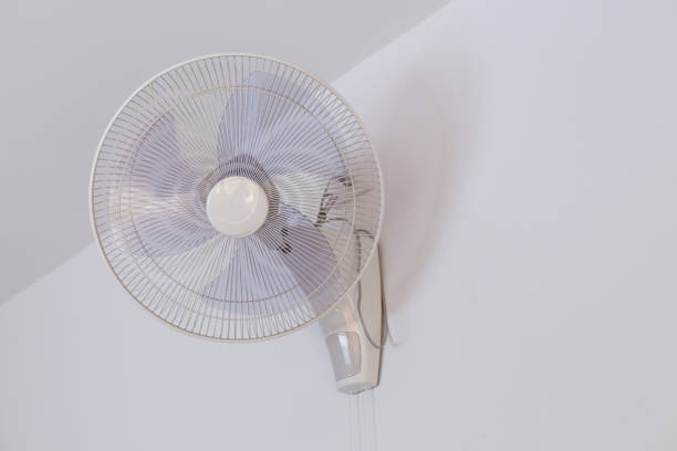 istock electric fan hanging on white mortar wall 1084032712