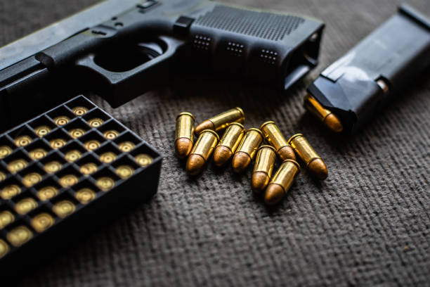 пули и пистолет на черном бархатном столе - bullet �стоковые фото и изображения