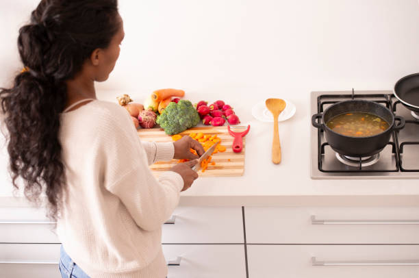 istock Woman chopping carrots and other vegetables at kitchen. 1084041230