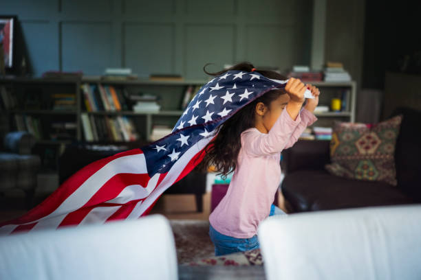 cheerful girl running with american flag at home - house home interior flag usa imagens e fotografias de stock
