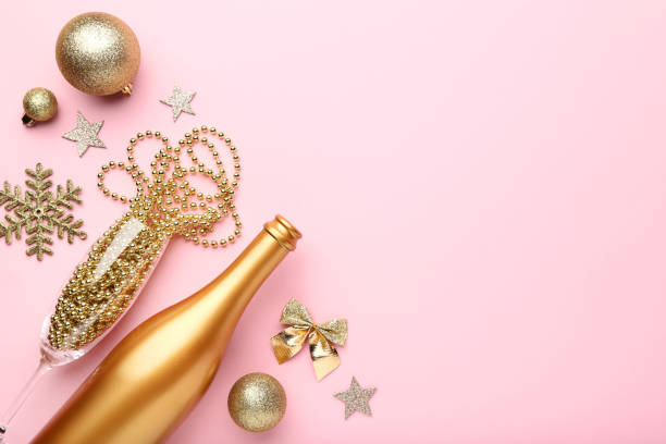 istock Champagne bottle with christmas decorations on pink background 1084042998