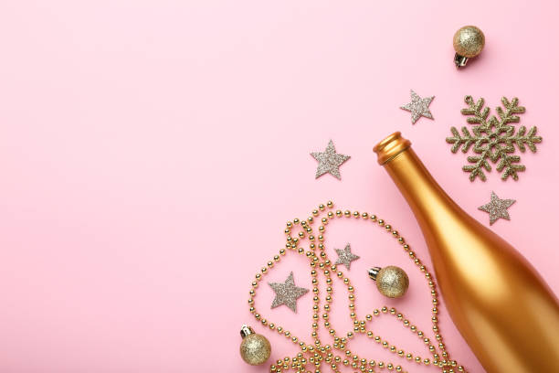 istock Champagne bottle with christmas decorations on pink background 1084043930
