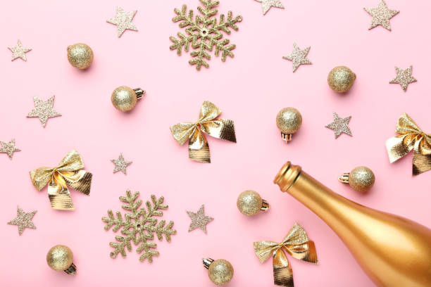 istock Champagne bottle with christmas decorations on pink background 1084044236