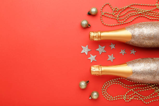istock Champagne bottles with christmas decorations on red background 1084046568