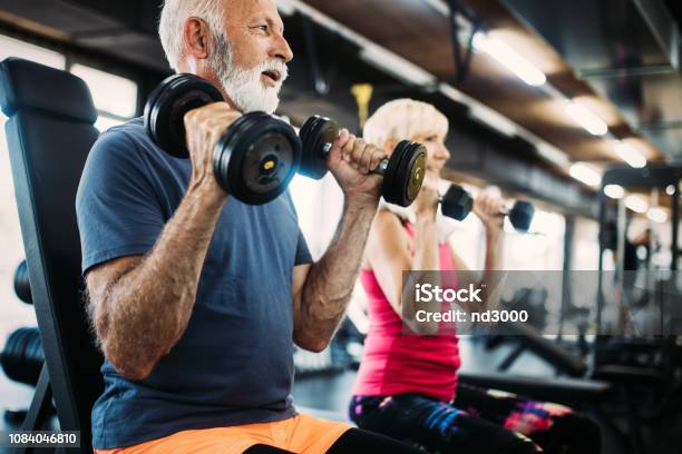 Senior Fit Man And Woman Doing Exercises In Gym To Stay Healthy Stock Photo - Download Image Now