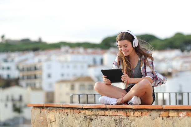 adolescente feliz em ver e ouvir vídeo em um tablet - rural watch - fotografias e filmes do acervo