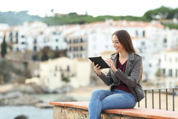 istock Happy woman using a tablet in a coast town 1084046978
