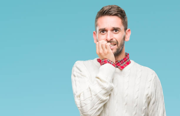 istock Young handsome man wearing winter sweater over isolated background looking stressed and nervous with hands on mouth biting nails. Anxiety problem. 1084051092
