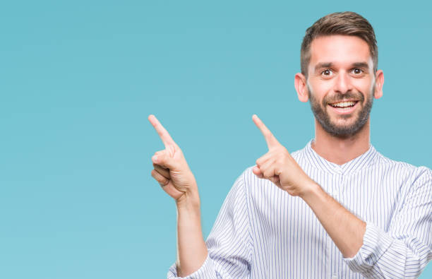 istock Young handsome man over isolated background smiling and looking at the camera pointing with two hands and fingers to the side. 1084051118