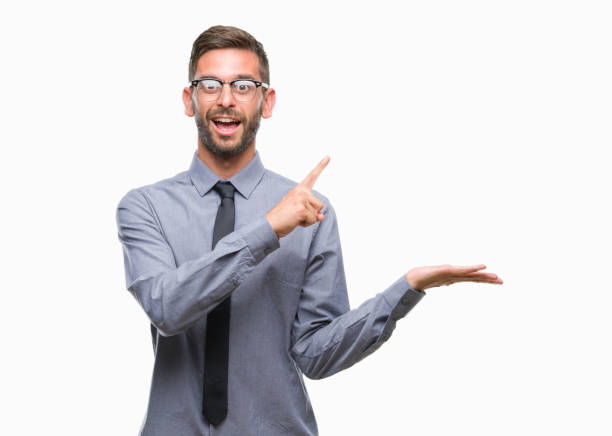 istock Young handsome business man over isolated background amazed and smiling to the camera while presenting with hand and pointing with finger. 1084051156