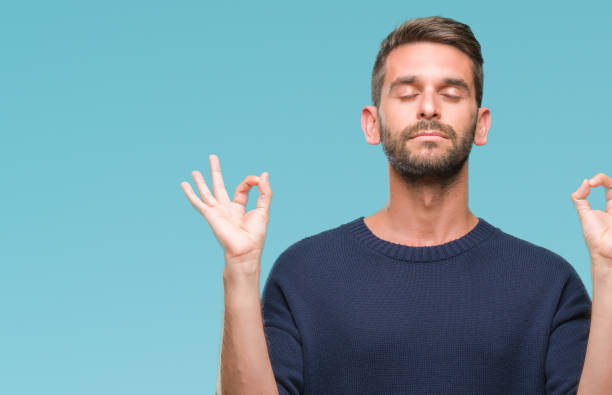 istock Young handsome man wearing winter sweater over isolated background relax and smiling with eyes closed doing meditation gesture with fingers. Yoga concept. 1084051290