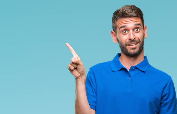 istock Young handsome man over isolated background with a big smile on face, pointing with hand and finger to the side looking at the camera. 1084051466