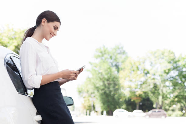 実業家のスマート フォン、屋外の車の傾きをチェック - car smart phone business businesswoman ストックフォトと画像
