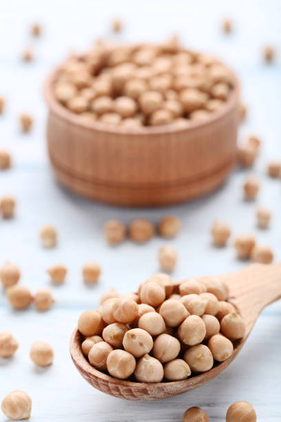 istock Chickpeas in spoon and bowl on wooden table 1084055040