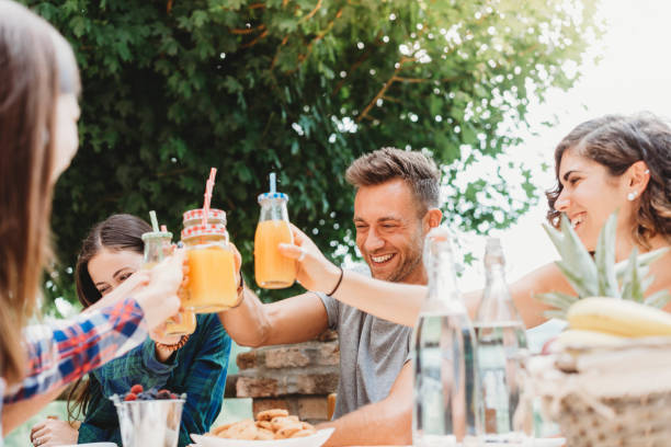 Group of friends having a break in the countryside together drinking juices Group of friends having a break in the countryside together drinking juices juice drink stock pictures, royalty-free photos & images