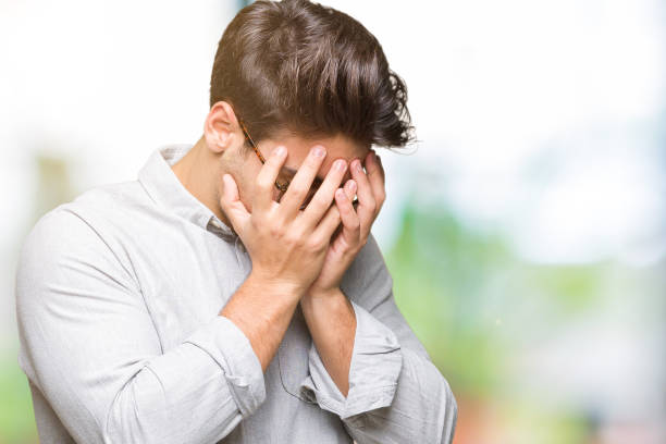 istock Young handsome man wearing glasses over isolated background with sad expression covering face with hands while crying. Depression concept. 1084059300