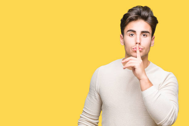 istock Young handsome man over isolated background asking to be quiet with finger on lips. Silence and secret concept. 1084060482