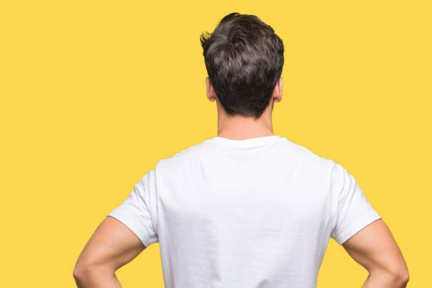 istock Young handsome man wearing white t-shirt over isolated background standing backwards looking away with arms on body 1084060582