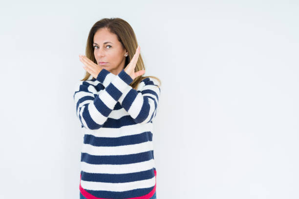 istock Beautiful middle age woman wearing navy sweater over isolated background Rejection expression crossing arms doing negative sign, angry face 1084068552