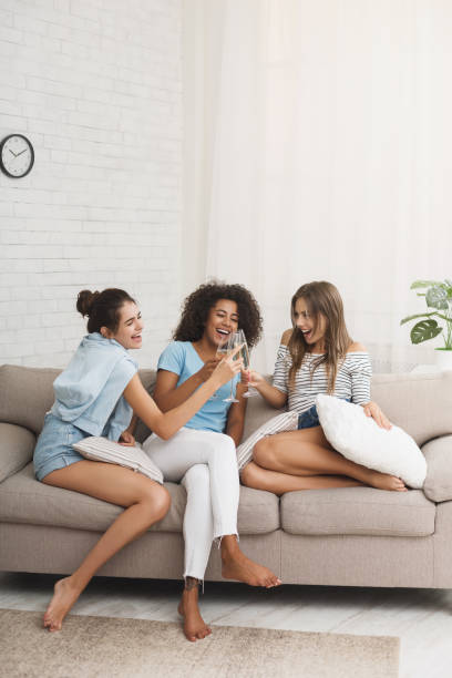 istock Girlfriends spending evening together, drinking champagne at home 1084069340
