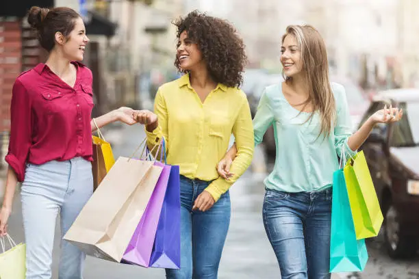 Photo of Women walking with shopping bags in the city