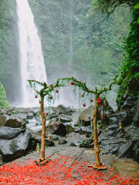 istock Arch with beautiful flowers and red petals. Wedding ceremony at waterfall. 1084072682