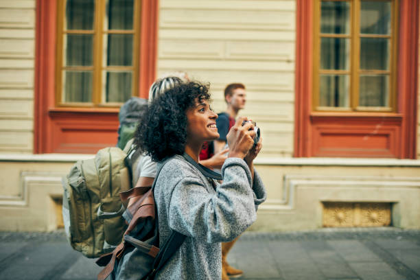 os amigos da millennial visitam a cidade estrangeira - mochileiro - fotografias e filmes do acervo