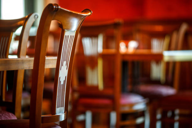 istock Wooden chairs put up against tables in an empty cafeteria 1084083442