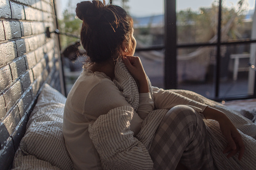 Portrait of a young beautiful woman waking up with a morning sunlight