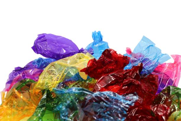 istock Coloured sweet wrappers on white background with copy space 1084085318
