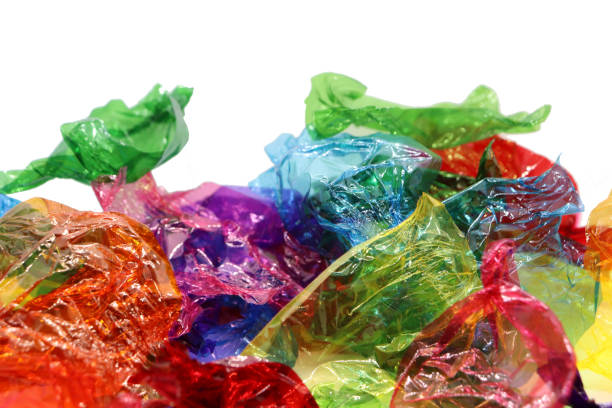 istock Coloured sweet wrappers on white background with copy space 1084085548