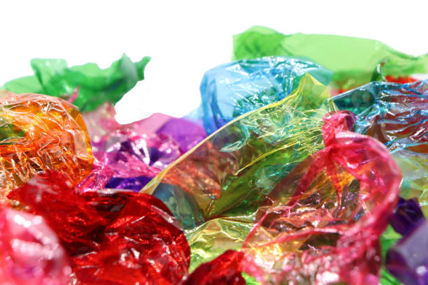 istock Coloured sweet wrappers on white background with copy space 1084085604