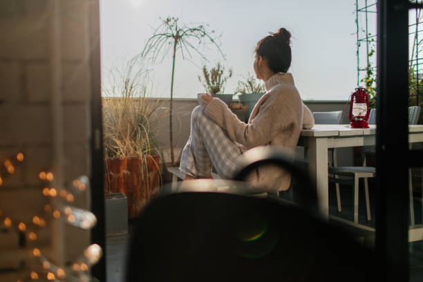 Relaxing mornings on my terrace Young woman having a relaxing start of a day on her terrace apartment balcony garden stock pictures, royalty-free photos & images