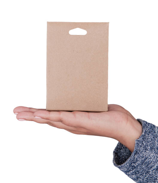 istock Hand holding blank carton box. Mockup for design 1084097380
