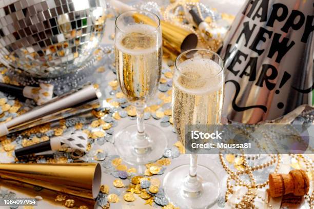 快樂的新年慶祝概念主題與關閉在兩杯香檳 迪斯可球覆蓋在鏡子 噪音製造商和党的喇叭 五彩紙屑 珠子和銀背景軟木塞 照片檔及更多 新年前夜 照片