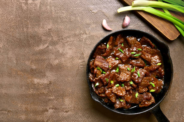 Mongolian beef Beef stewed in soy sauce with spices in asian style on brown background with copy space. Mongolian beef. Top view, flat lay beef stew stock pictures, royalty-free photos & images
