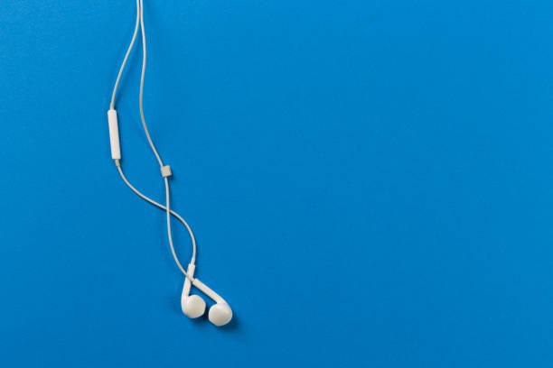 istock White earphones on blue background 1084099968