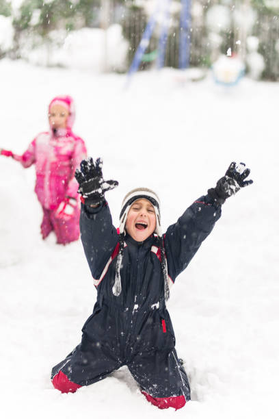 istock Kids playing in snow. Children play outdoors in winter snowfall. 1084103228