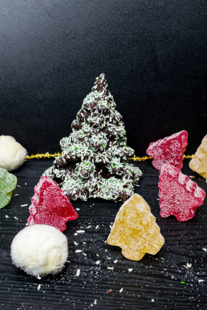 istock Chocolate Christmas tree, marmalade colorful trees on black background 1084107074