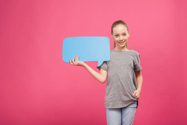 istock blonde youngster holding blue speech bubble, isolated on pink 1084108534